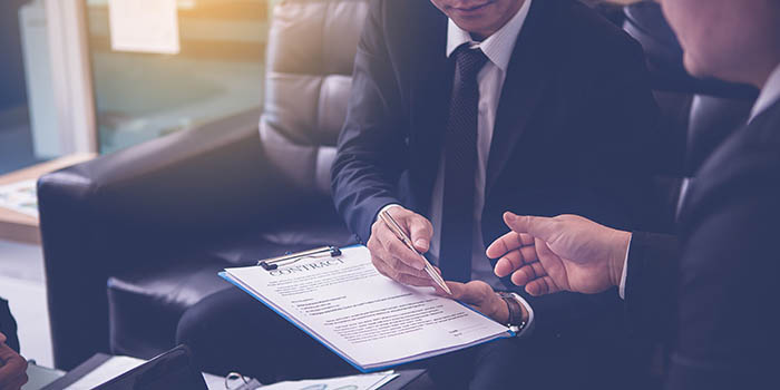 Businessman asks another person to sign a deal