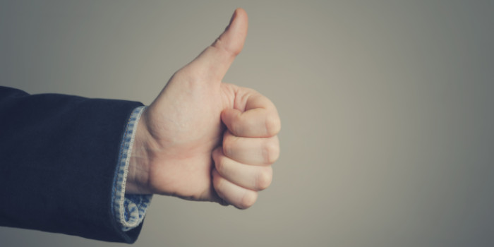 Close up photo of the hand of a businessman giving thumb up